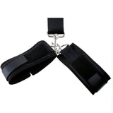 Dettaglio polsiere nere collegate con moschettone metallico e velcro