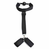 Accessorio BDSM nero ball-gag con polsiere collegate su sfondo bianco