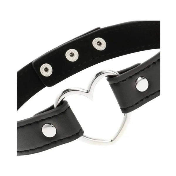 Dettaglio cuore metallico lucido e fibbie argentate su choker pelle vegana nero