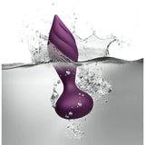 Plug anale Desire viola impermeabile a spirale immerso nell'acqua con spruzzi