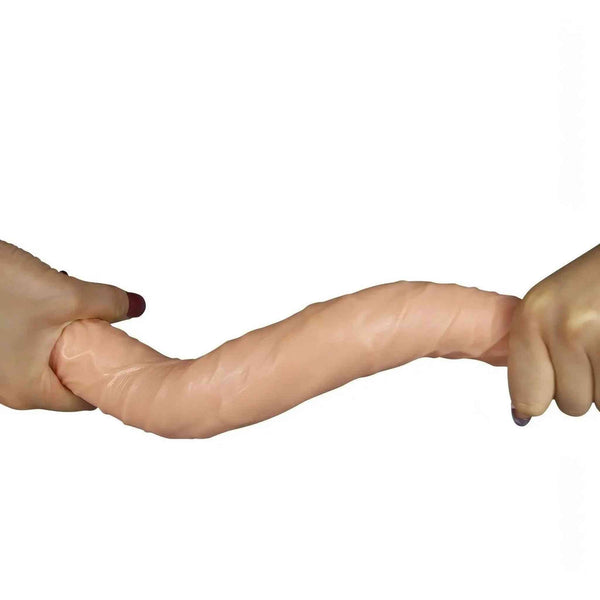 Doppio dildo rosa carne teso tra mani per evidenziare elasticità