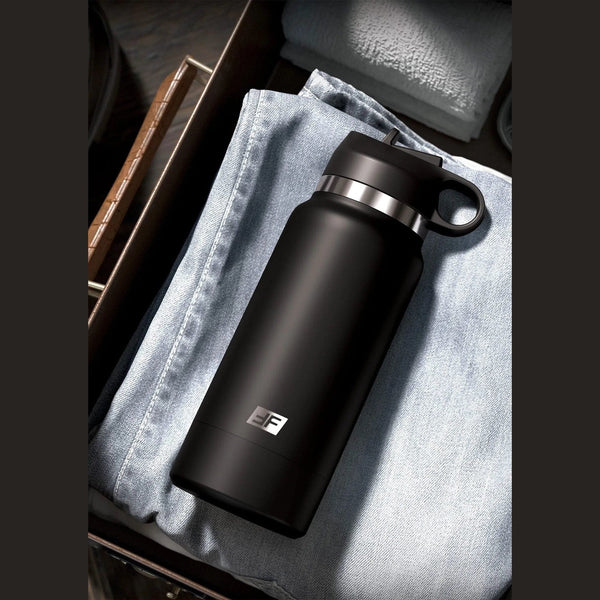 Fap Flask Thrill Seeker nero riposto in valigia su tessuto jeans