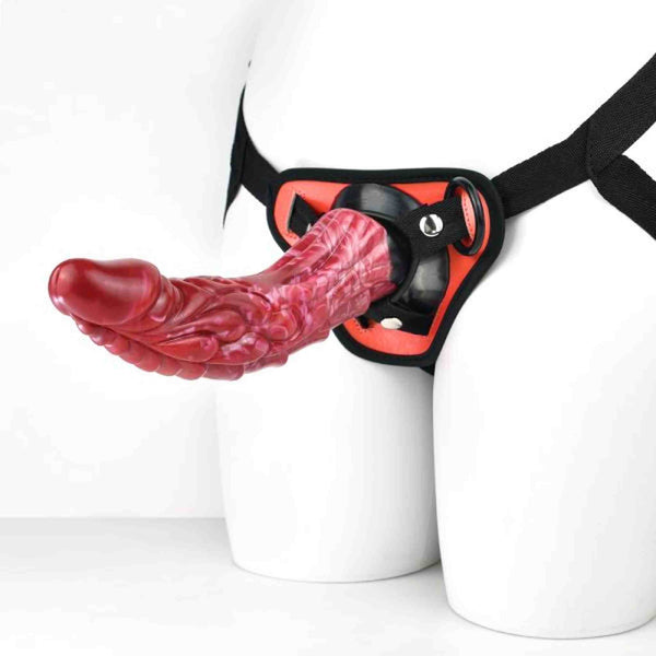 Accessorio sessuale rosso con supporto centrale arancione e cinghie nere