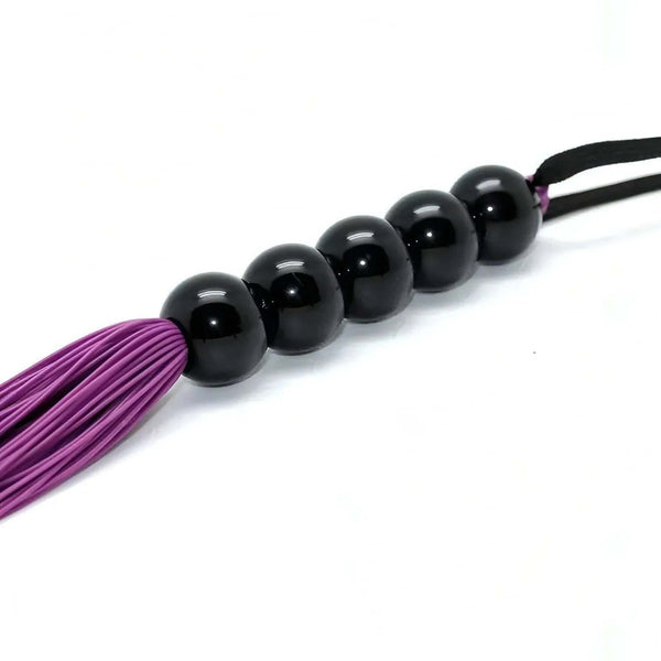 Dettaglio fruste silicone viola e sfera nera lucida