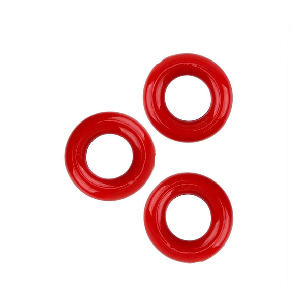 Tre anelli cockring rossi disposti asimmetricamente su sfondo bianco
