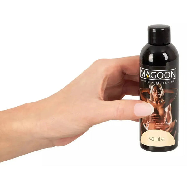 Mano che tiene olio per massaggi Magoon vaniglia 100 ml nero