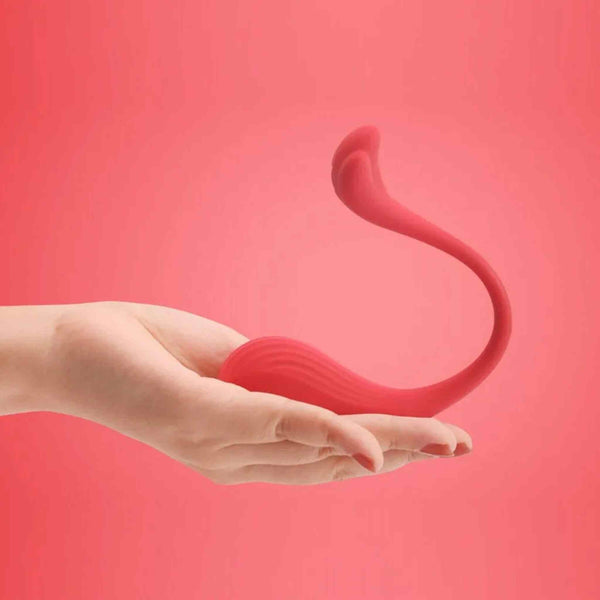 Mano femminile che tiene ovulo rosso ergonomico a forma di C