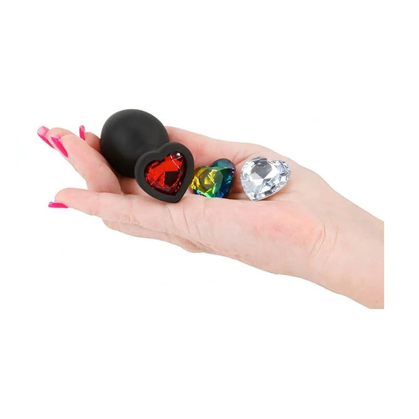 Plug anale nero in silicone con gemma cuore rossa tenuto in mano per mostrare le dimensioni