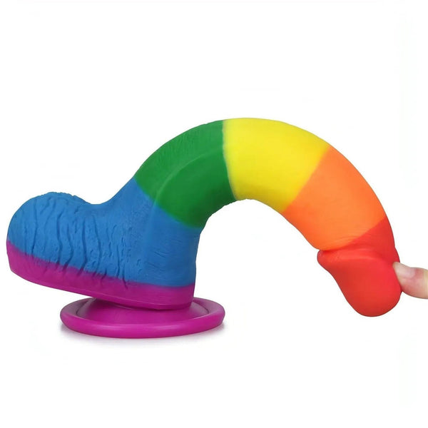 Dildo arcobaleno in silicone flesso con mano che tocca la punta rossa