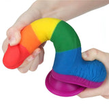 Dildo silicone arcobaleno flessibile tenuto in mano per mostrare elasticità