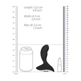 Confronto dimensioni stimolatore prostatico nero in silicone con scala metrica e oggetti comuni