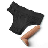 Guaina nera per pene con foro centrale e dildo realistico accanto su sfondo bianco
