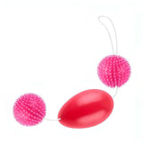 Vista laterale palline vaginali rosa con superficie testurizzata e filo di controllo
