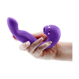 Mano che impugna vibratore viola a forma di U per stimolazione clitoridea e G-spot