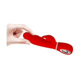 Vibratore rabbit rosso in silicone tenuto in mano con scanalature verticali