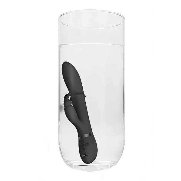 Vibratore rabbit nero VIVE HALO immerso in bicchiere trasparente d'acqua su sfondo bianco